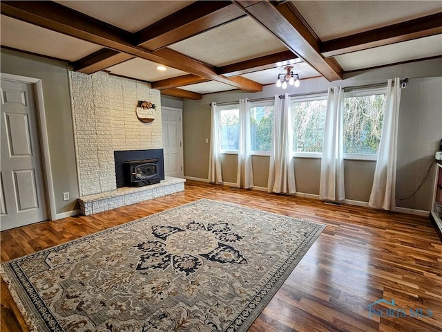 living room featuring wood-type flooring, coffered ceiling, beam ceiling, and a notable chandelier