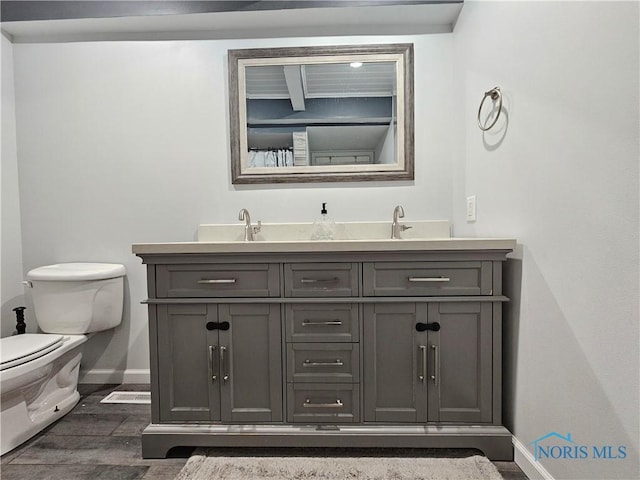 bathroom with vanity, toilet, and hardwood / wood-style floors