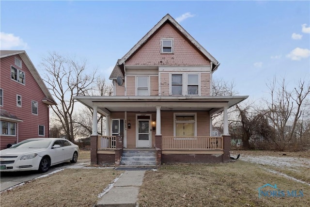 view of front of house with a front yard and a porch