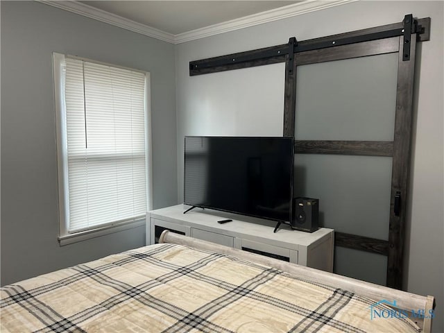 bedroom with ornamental molding and a barn door