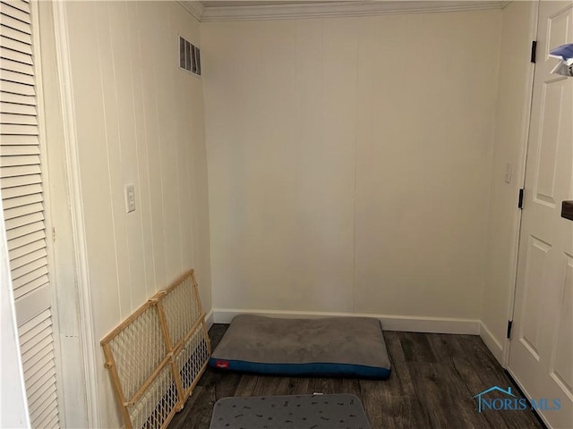 laundry room featuring dark wood-type flooring and ornamental molding