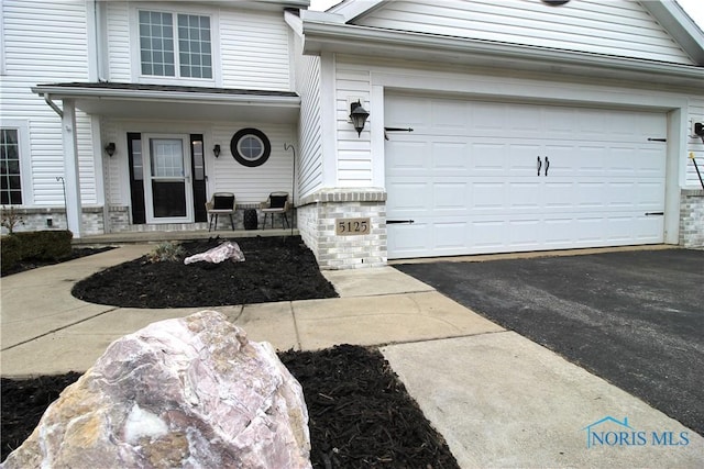 doorway to property with a porch and a garage