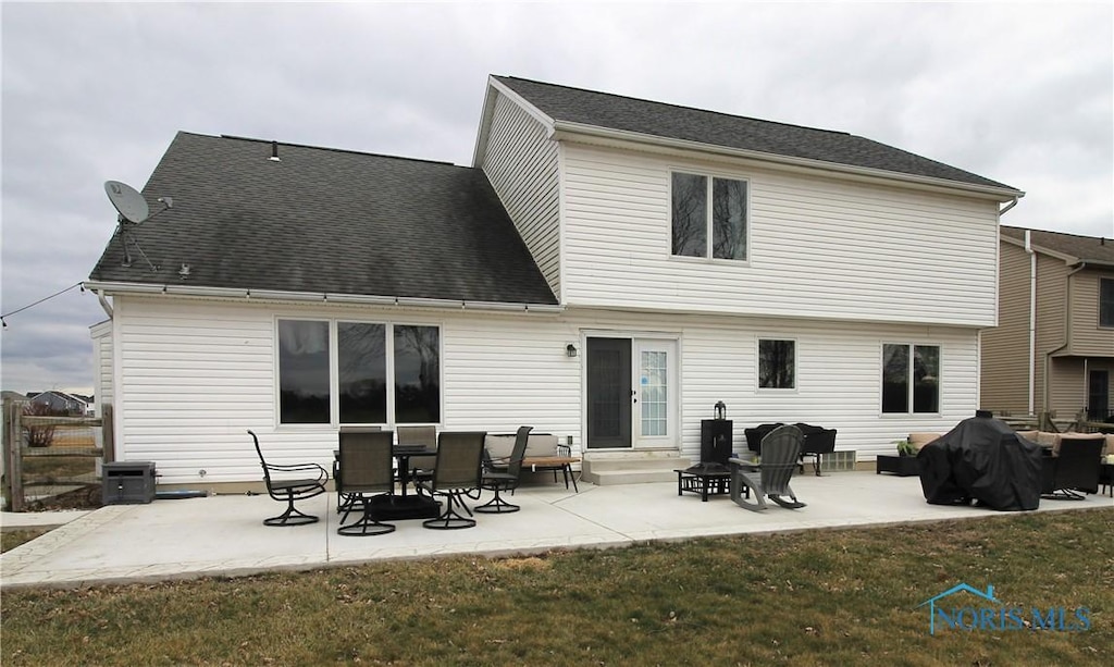 rear view of house featuring a yard, central AC unit, and a patio area