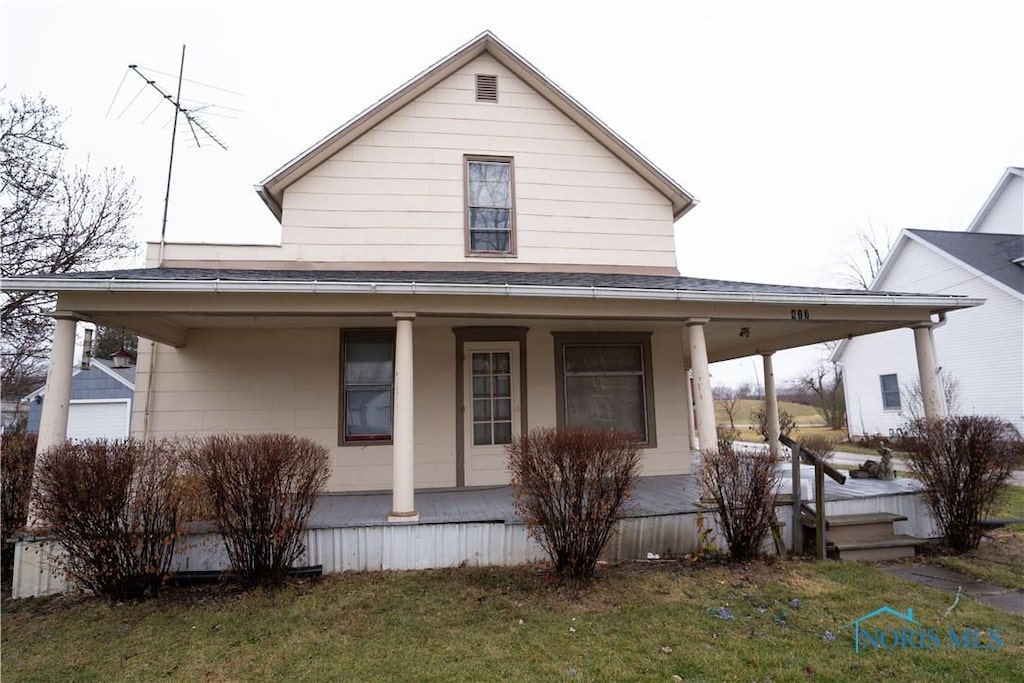 country-style home featuring a front yard and covered porch