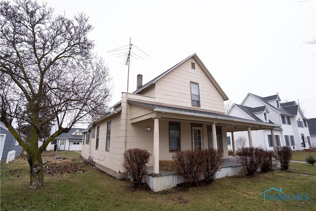 view of front of property with covered porch and a front lawn