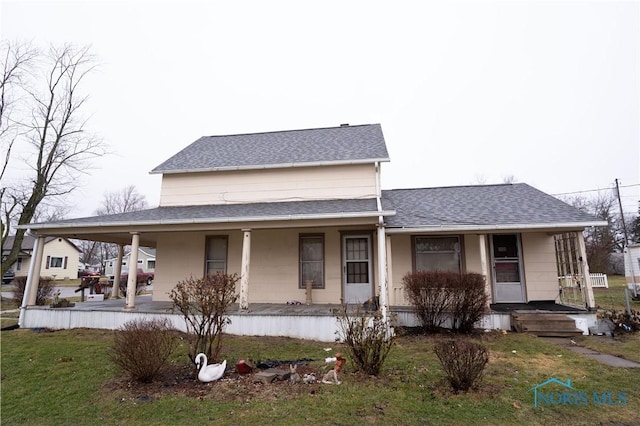 farmhouse featuring a front yard and a porch