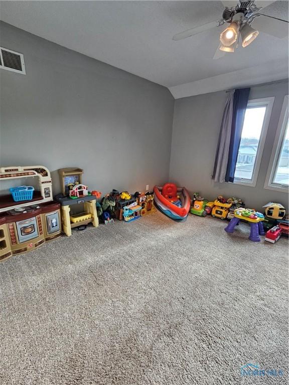 playroom with vaulted ceiling, carpet floors, and ceiling fan