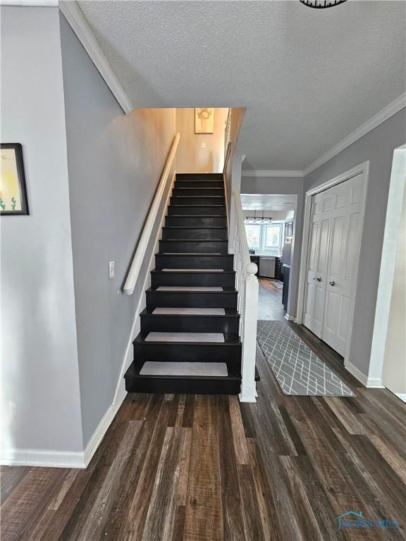 stairway featuring hardwood / wood-style flooring, ornamental molding, and a textured ceiling