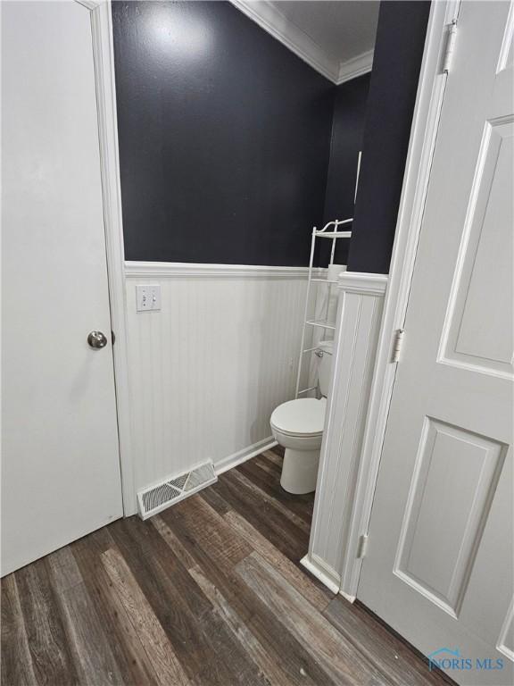 bathroom featuring ornamental molding, toilet, and hardwood / wood-style floors