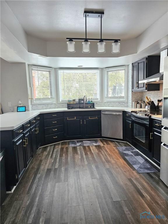 kitchen featuring pendant lighting, sink, dishwasher, electric range, and dark hardwood / wood-style floors