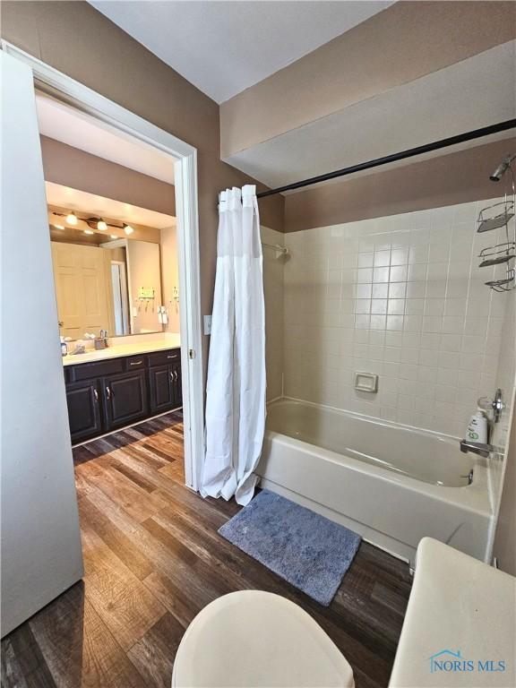 full bathroom with vanity, toilet, shower / tub combo, and wood-type flooring