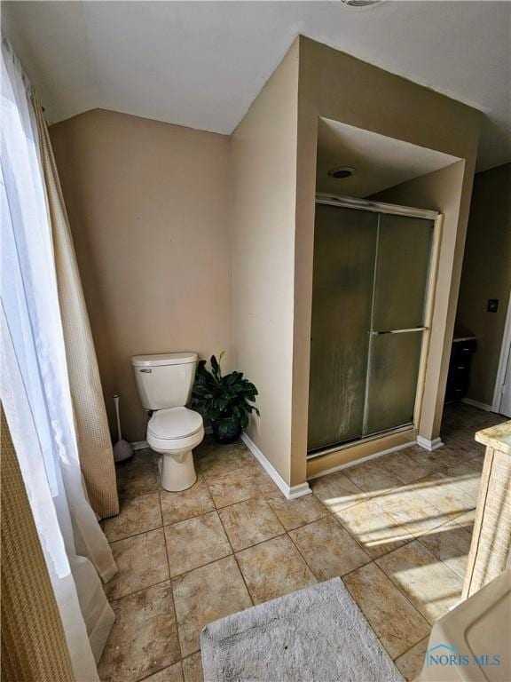 bathroom with lofted ceiling, an enclosed shower, and toilet