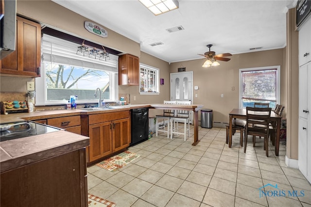 kitchen with light tile patterned floors, visible vents, brown cabinetry, dishwasher, and a sink