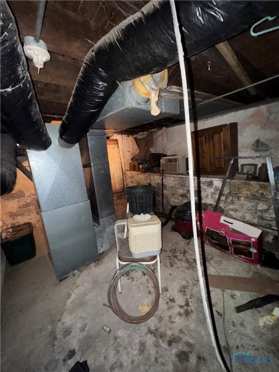 unfinished basement featuring an AC wall unit