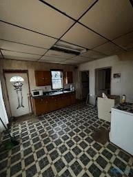 kitchen with dark countertops, a paneled ceiling, and tile patterned floors