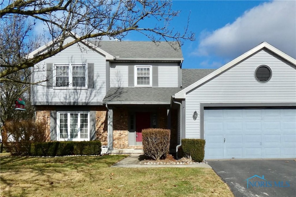 view of property with a garage and a front yard