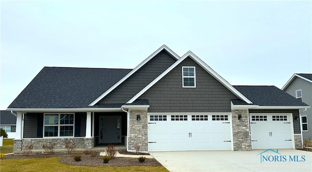 craftsman inspired home with a garage and a front lawn