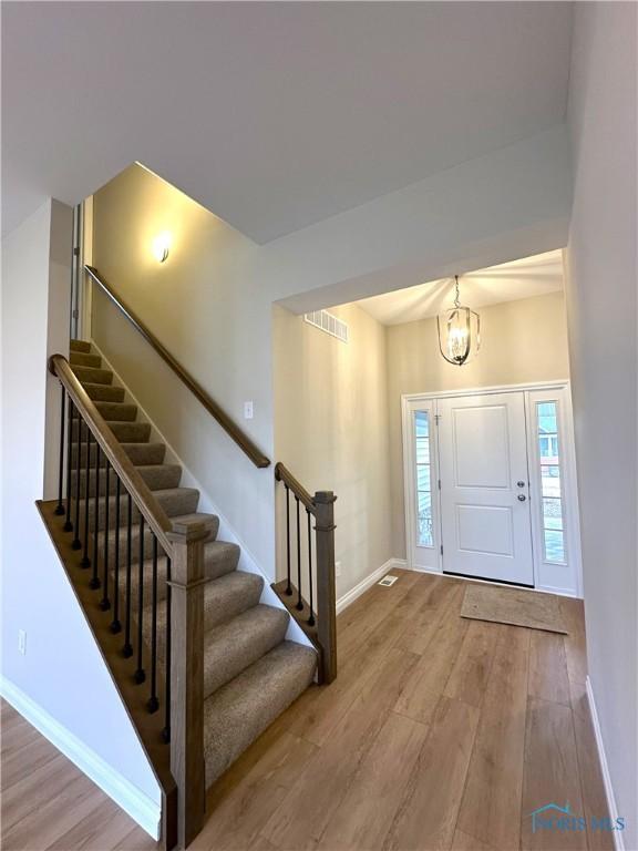 entryway featuring hardwood / wood-style flooring and a chandelier