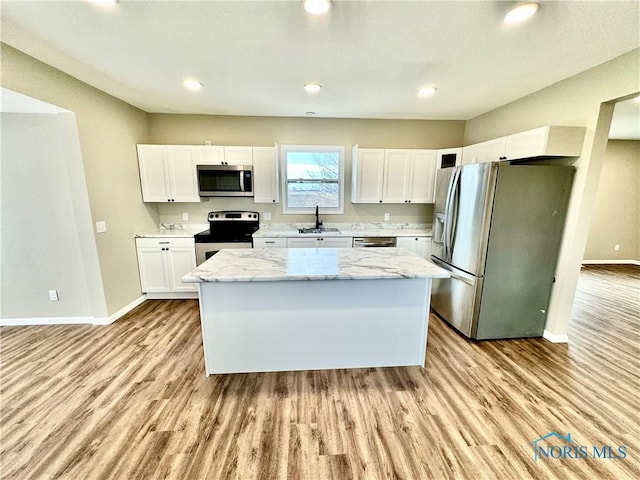 kitchen with a kitchen island, white cabinetry, appliances with stainless steel finishes, and sink