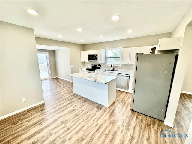 kitchen with white cabinetry, sink, light hardwood / wood-style flooring, and appliances with stainless steel finishes