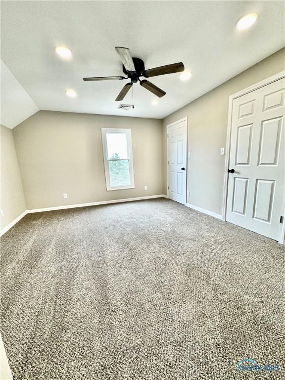 unfurnished bedroom with vaulted ceiling, carpet flooring, and ceiling fan