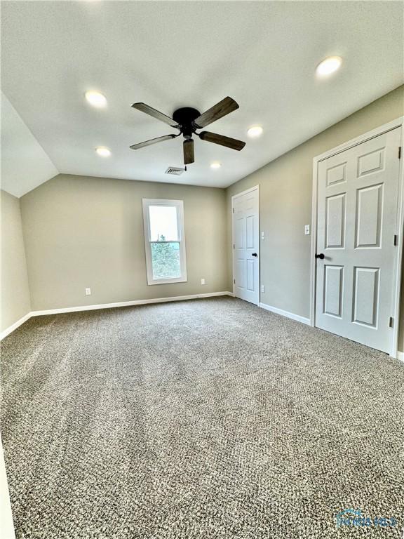 unfurnished bedroom with vaulted ceiling, carpet floors, and ceiling fan