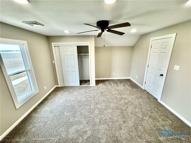 unfurnished bedroom featuring ceiling fan, a closet, a textured ceiling, and carpet