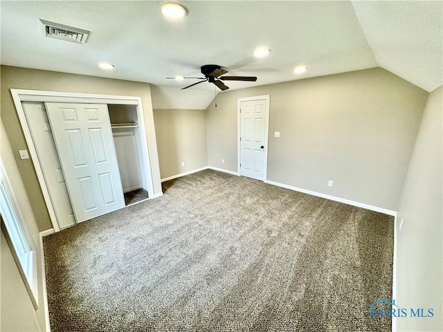 unfurnished bedroom featuring lofted ceiling, carpet floors, ceiling fan, and a closet