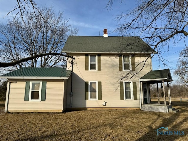 rear view of property with a yard