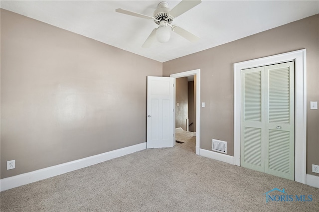 unfurnished bedroom with carpet floors, ceiling fan, and a closet