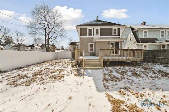 snow covered back of property featuring a deck