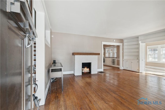 unfurnished living room featuring dark hardwood / wood-style floors and a fireplace