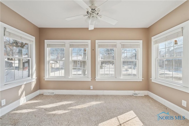 unfurnished sunroom featuring ceiling fan