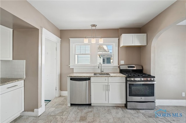 kitchen with stainless steel appliances, decorative light fixtures, sink, and white cabinets