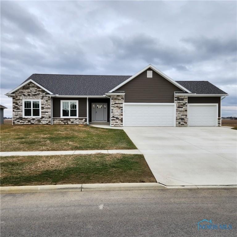 single story home featuring a garage and a front yard