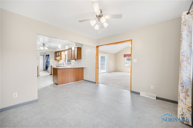 kitchen featuring ceiling fan, lofted ceiling, and kitchen peninsula