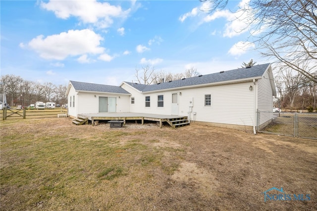 rear view of house with a deck and a lawn