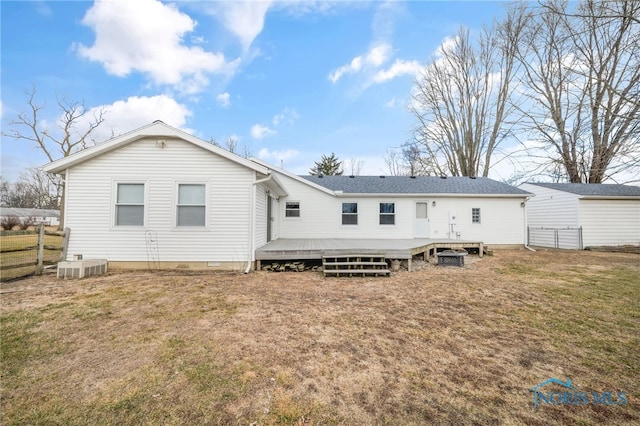 back of house featuring a deck, a lawn, and central air condition unit