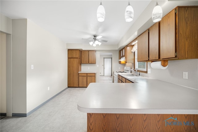 kitchen featuring sink, hanging light fixtures, white range with gas stovetop, ceiling fan, and kitchen peninsula