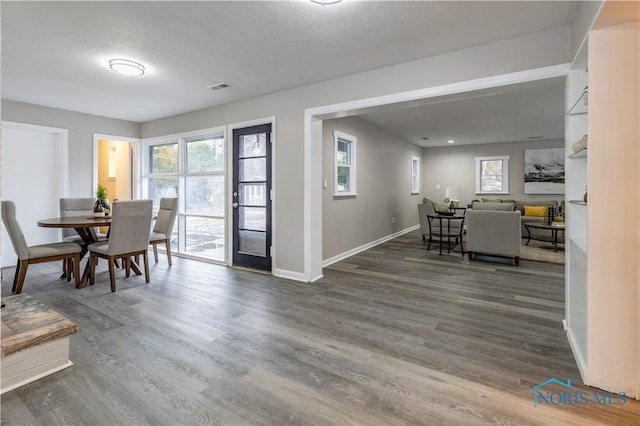 dining room featuring a healthy amount of sunlight and dark hardwood / wood-style flooring