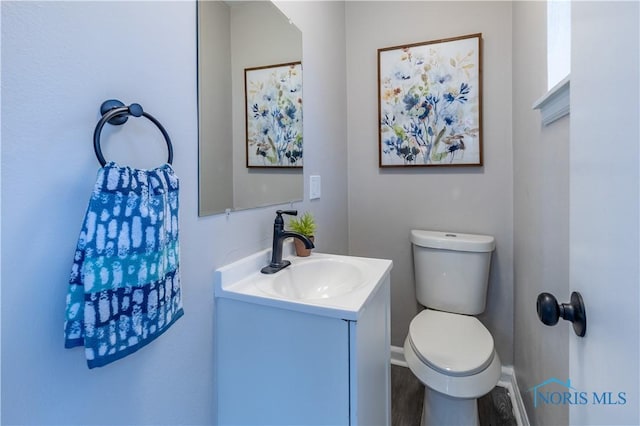 bathroom with hardwood / wood-style flooring, vanity, and toilet