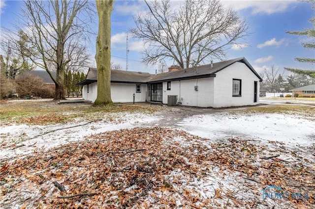 snow covered property with central AC unit