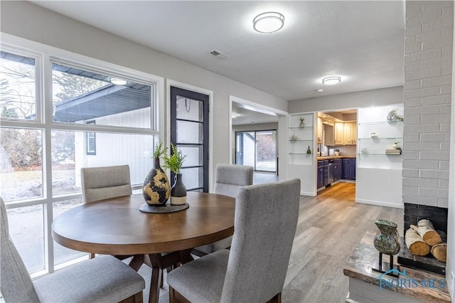 dining space with a fireplace and light hardwood / wood-style floors