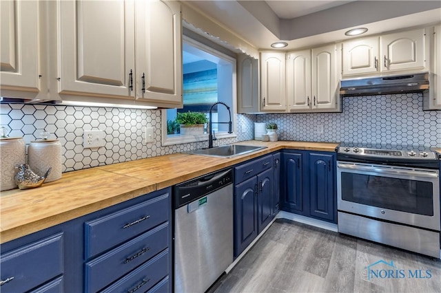 kitchen featuring sink, blue cabinetry, stainless steel appliances, white cabinets, and wood counters