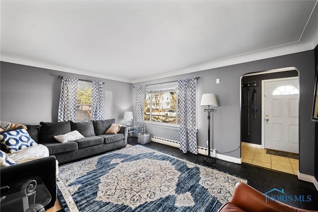 living room featuring dark tile patterned floors, ornamental molding, and a baseboard heating unit