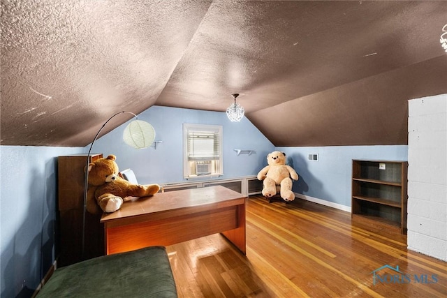 home office with hardwood / wood-style flooring, vaulted ceiling, a textured ceiling, and cooling unit