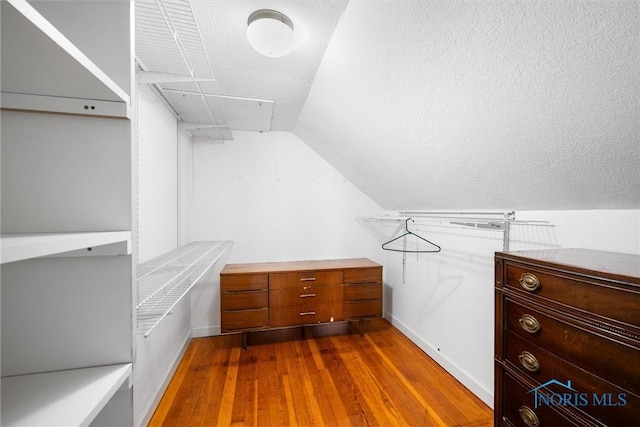 spacious closet featuring wood-type flooring and vaulted ceiling