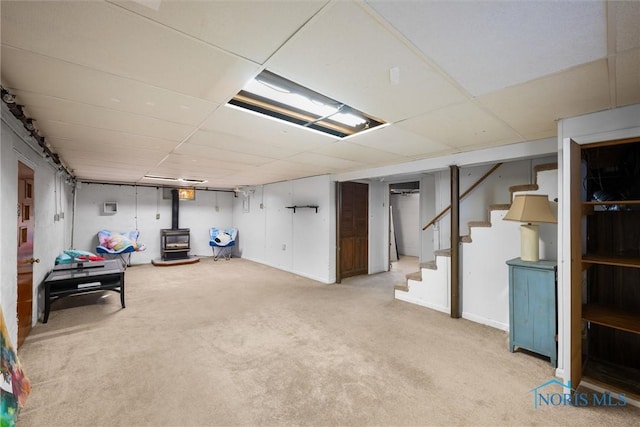 basement featuring a wood stove and light carpet