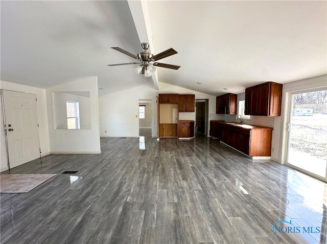 interior space featuring ceiling fan, sink, vaulted ceiling with beams, and dark hardwood / wood-style flooring