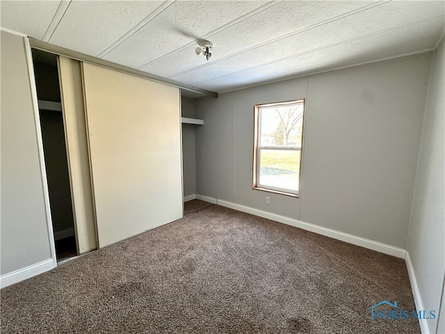 unfurnished bedroom featuring a closet, a textured ceiling, and carpet